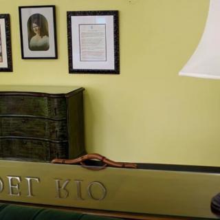 A cozy interior with a lamp, framed pictures, and a decorative mirror.