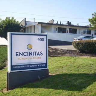 Sign for Encinitas Nursing and Rehabilitation Center with building in the background.