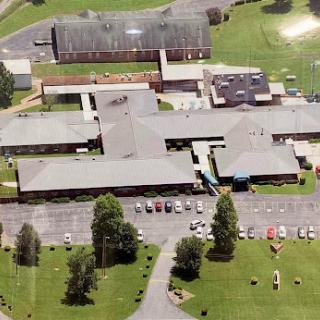 Aerial view of a school campus surrounded by well-maintained lawns and parking areas.