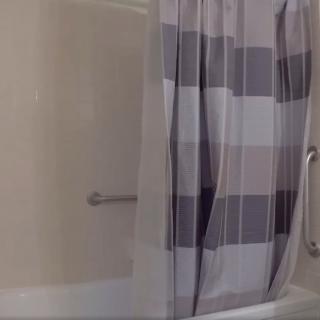 A bathroom featuring a bathtub with a striped shower curtain.