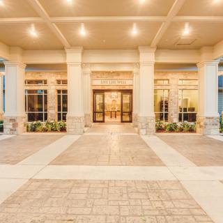 A well-lit building entrance with tall columns and large windows.