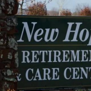 A sign for New Hope Retirement & Care Center amidst outdoor surroundings.