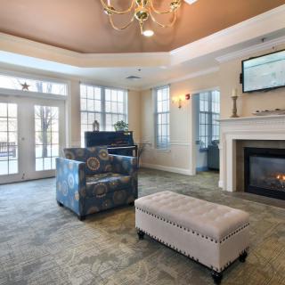 A cozy living room with a fireplace, plush seating, and elegant decor.