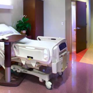 A hospital room with a patient bed and medical equipment.