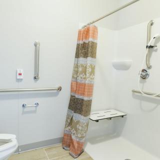 A handicap accessible bathroom with shower and grab bars.