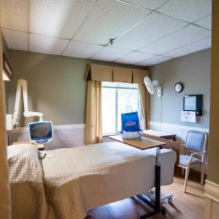 An empty hospital room with a bed and medical equipment.