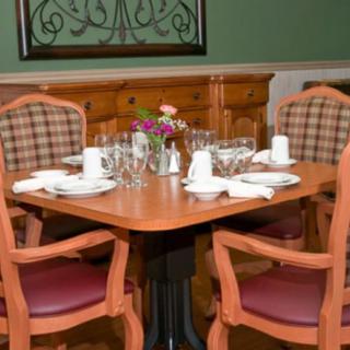 A neatly set dining table with four chairs in a restaurant.