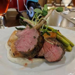 A gourmet plate of lamb with asparagus and vegetables.