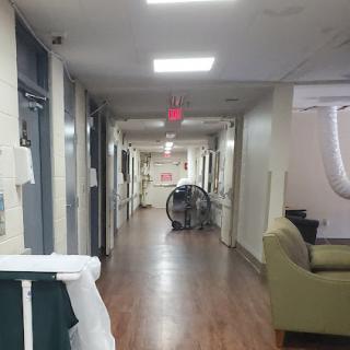 A serene corridor in a hospital with seating and medical equipment.