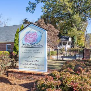 A welcoming sign for a business, surrounded by well-maintained landscaping.