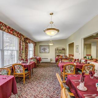 A cozy dining room with elegantly set tables and warm lighting.