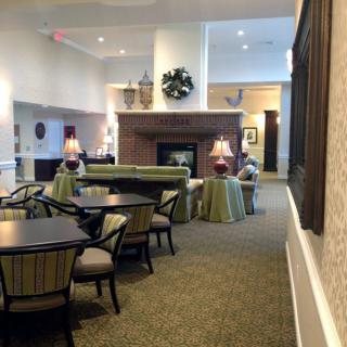 A cozy lounge area with comfortable seating, tables, and a central fireplace.