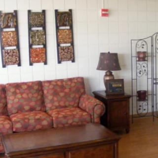 A cozy living room with patterned sofa, coffee table, and decorative wall art.
