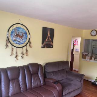 A cozy living room featuring leather sofas and decorative wall art.