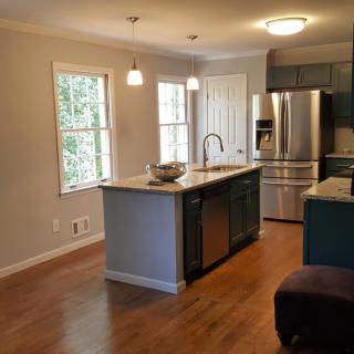 A modern kitchen featuring stainless steel appliances and an island counter with pendant lighting.