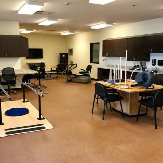A well-equipped physical therapy clinic with various exercise machines and rehabilitation tools.