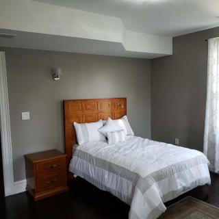 A minimalist bedroom with a single bed and wooden furniture.