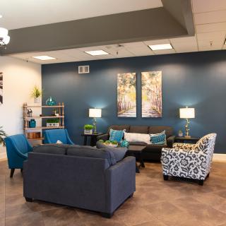 A modern living room featuring blue accent walls, stylish furniture, and decorative artwork.