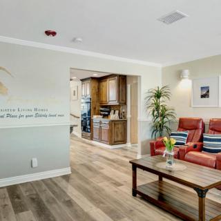 A cozy living room with red armchairs, a wooden coffee table, and a welcoming atmosphere.