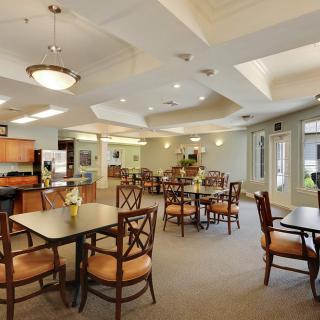 A spacious and well-lit dining area with several tables and chairs, featuring modern decor.