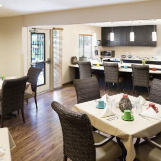 A modern dining area with a table set and an adjacent kitchen.
