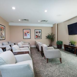 A cozy lounge area with comfortable seating, a television, and decorative artwork.