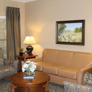 A cozy living room with a sofa and a coffee table, featuring tasteful decor and artwork.