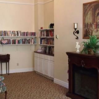 A cozy room with bookshelves and a fireplace.
