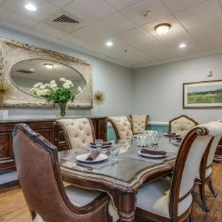 A beautifully set dining room featuring elegant furniture and a large decorative mirror.
