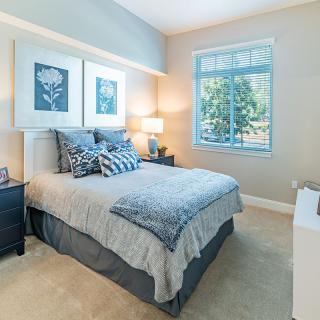 A cozy and well-decorated bedroom with a large window.