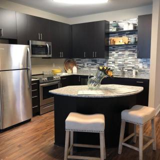 A modern kitchen with stainless steel appliances and a stylish backsplash.