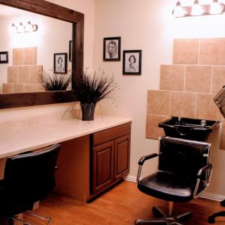 A modern hair salon interior with a styling station and washing area.