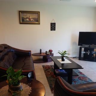 A cozy living room with a sofa, coffee table, and television.