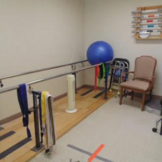 A therapy room equipped with parallel bars and exercise tools for rehabilitation.