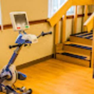 A rehabilitation room featuring an exercise bike and a small staircase.
