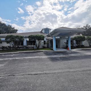 A view of a well-maintained residential building under a partly cloudy sky.