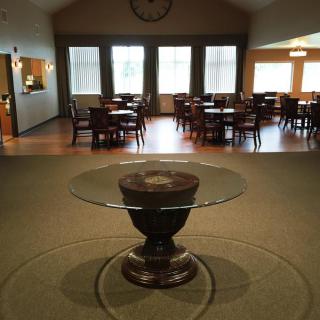 A dining area with multiple tables and chairs, featuring a glass table in the foreground.