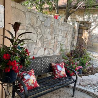 A cozy outdoor seating area adorned with vibrant flowers and decorative pillows, perfect for relaxation.