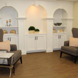 A modern living room with comfortable chairs and decorative shelving.