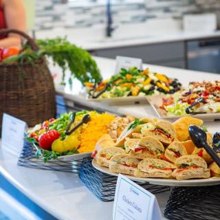 A vibrant buffet spread featuring sandwiches and fresh salads.