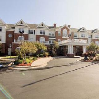 A multi-story residential building with a grand entrance and landscaped surroundings.