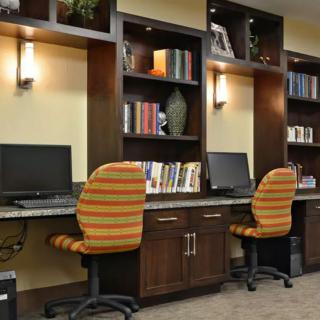 A cozy office workspace with computers and bookshelves.