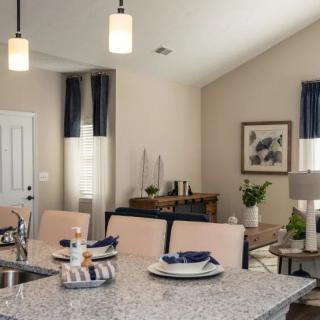 A modern kitchen and dining area featuring elegant table settings and stylish pendant lighting.
