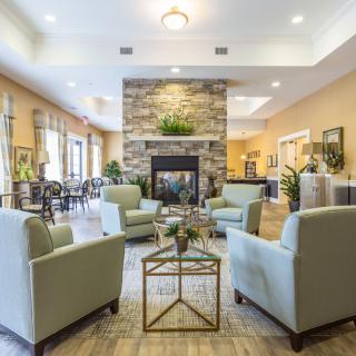 A modern living room with comfortable seating and a central fireplace.