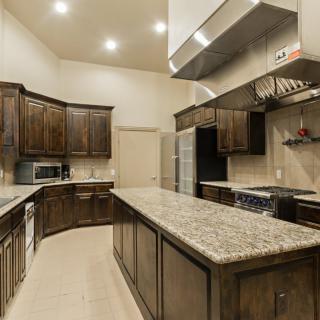 A modern kitchen with wood cabinets and a granite countertop.