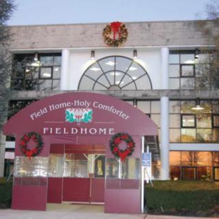 A festively decorated building entrance with Christmas wreaths and lighting.
