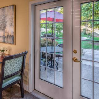 A cozy interior view featuring a glass patio door with an outdoor garden scene.