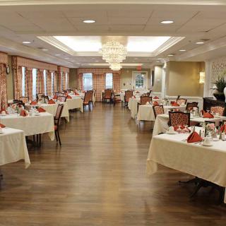 An elegantly decorated dining room with neatly arranged tables and a chandelier.