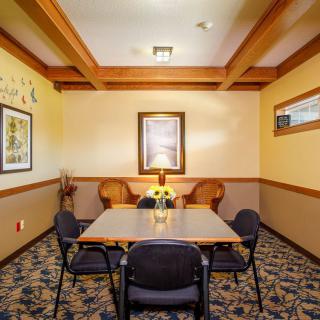 A small conference room with a table, chairs, and decorative paintings on the walls.