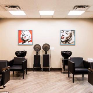 A modern hair salon interior with stylish artwork and seating.